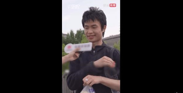 男子手提馒头和矿泉水接受采访